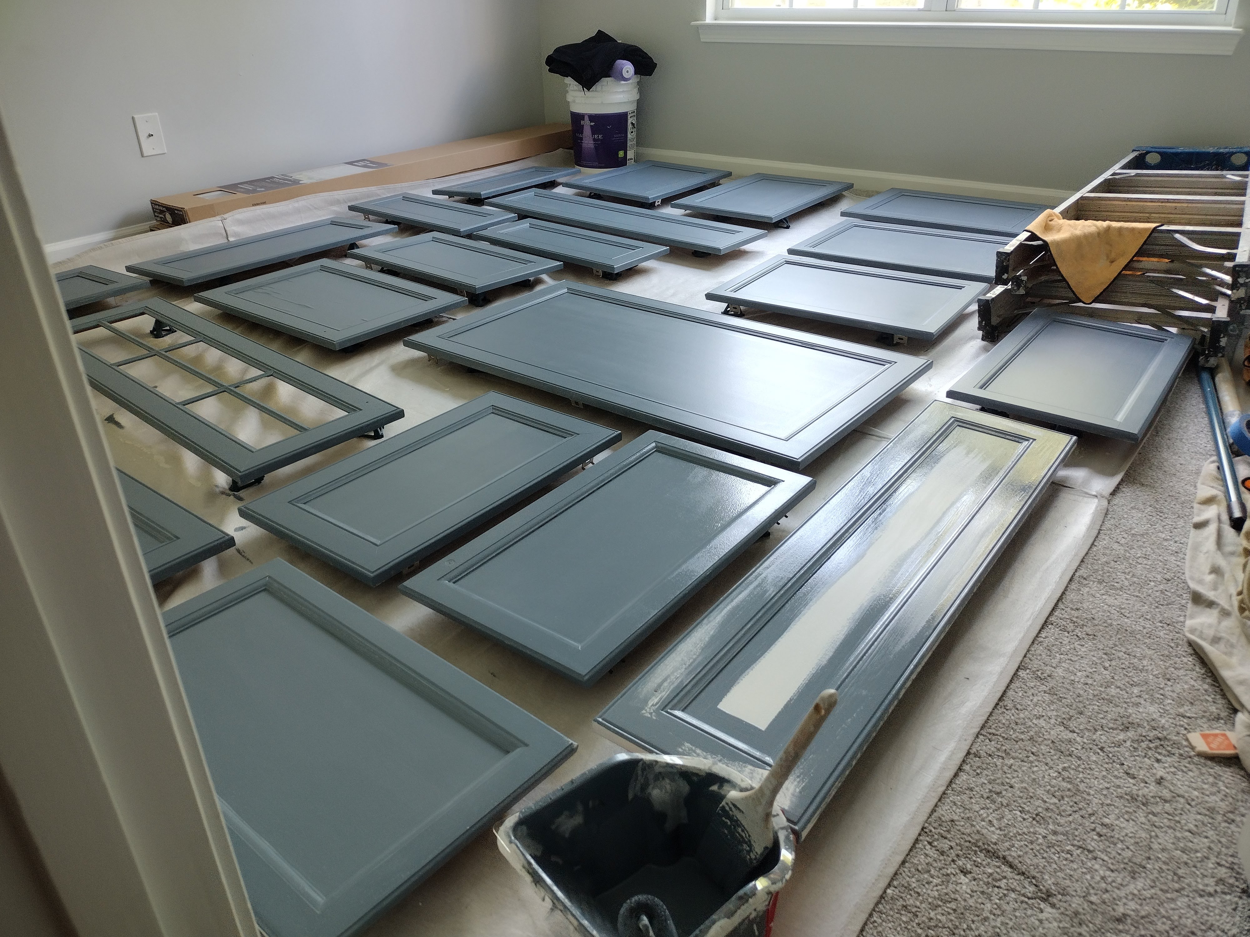 Cabinet doors drying between finish coats during an SJM cabinet refinishing project